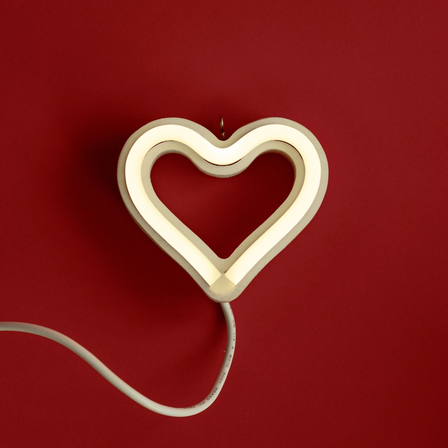 Cool white neon heart ornament glowing on red background - 3.5 inch LED neon ornament by Our Glowing Hearts handmade in Canada