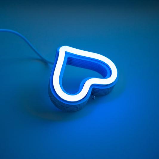 Close-up angled view of cyan neon heart ornament showing handcrafted layered wood frame and LED neon tubing construction by Our Glowing Hearts