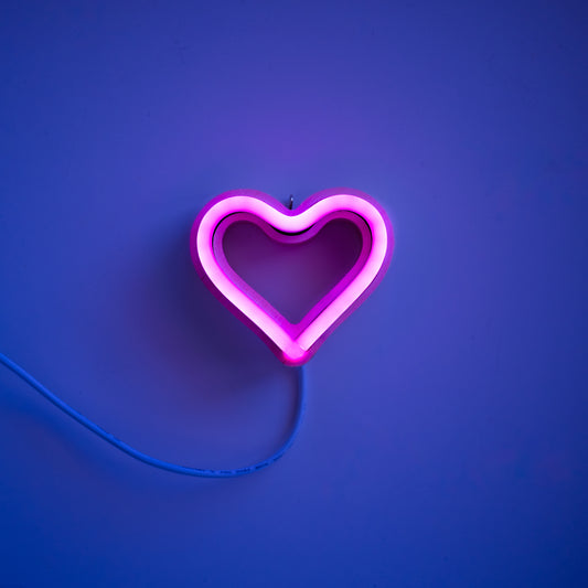 Magenta neon heart ornament art glowing against a purple background - 3 inch LED neon heart light by Our Glowing Hearts handmade in Canada