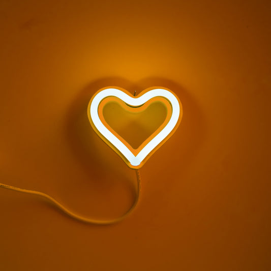 Orange neon heart ornament art glowing against an orange background - 3 inch LED neon heart light by Our Glowing Hearts handmade in Canada
