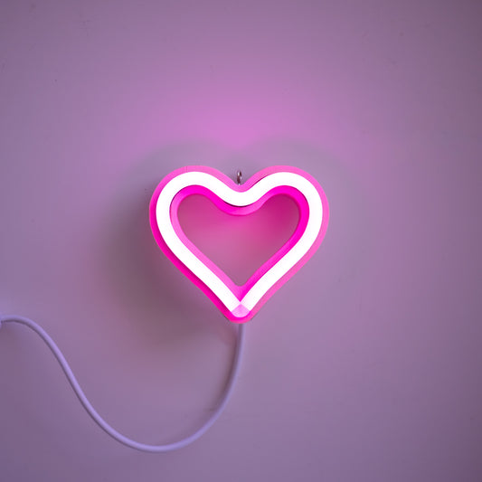 Pink neon heart ornament art glowing against a pink background - 3 inch LED neon heart light by Our Glowing Hearts handmade in Canada