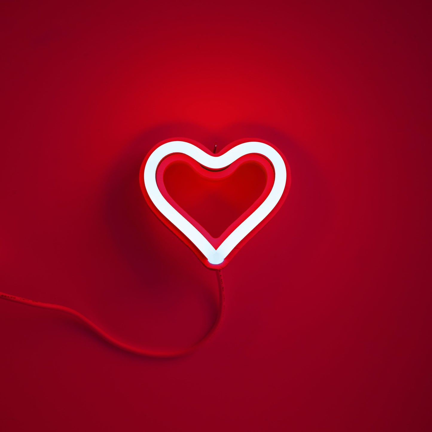 Red neon heart ornament glowing on red background - 3.5 inch LED neon ornament by Our Glowing Hearts handmade in Canada