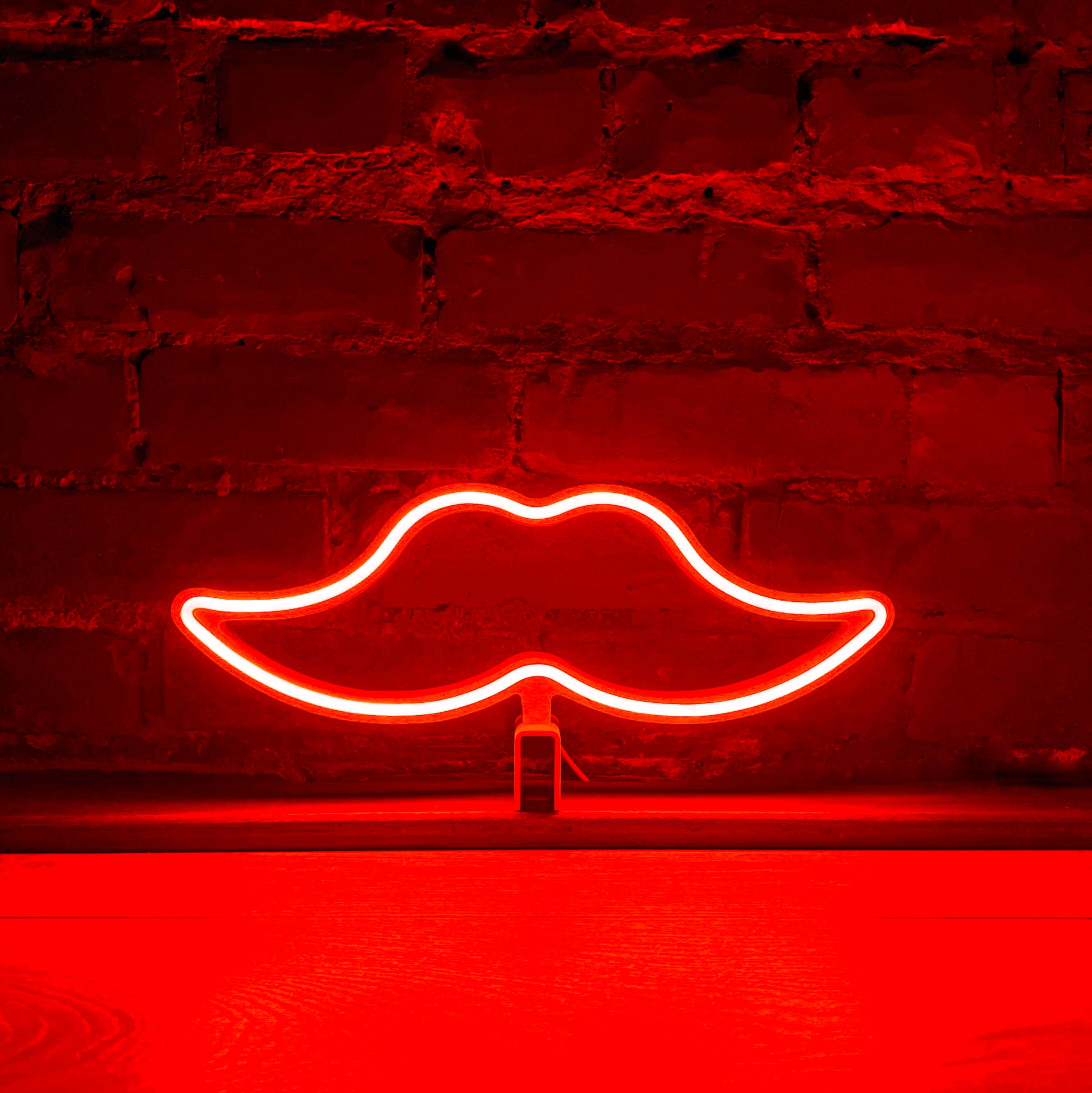 Red neon moustache art glowing against a brick wall - Movember LED neon moustache light by Our Glowing Hearts handmade in Canada