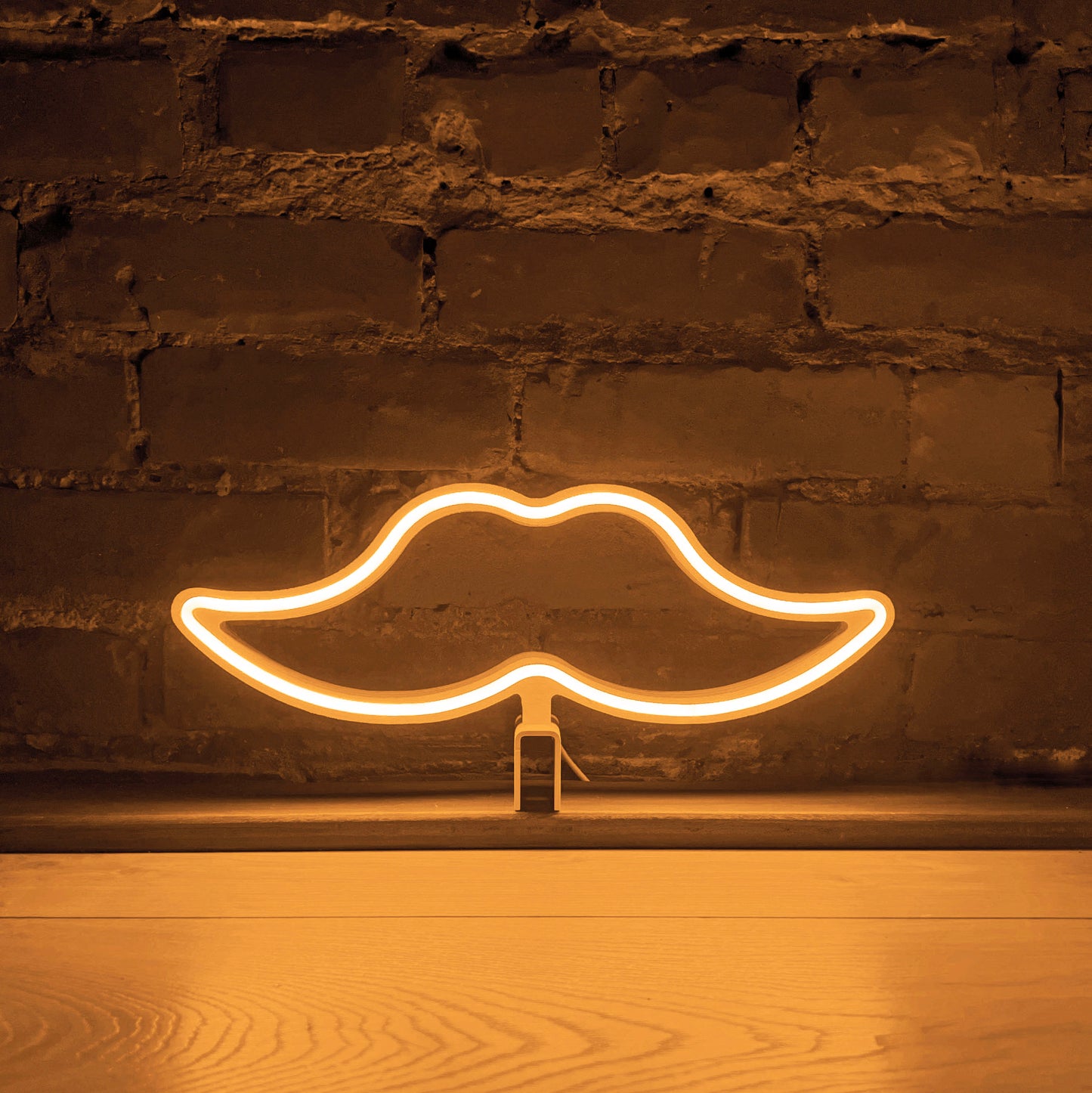 Warm white neon moustache art glowing against a brick wall - Movember LED neon moustache light by Our Glowing Hearts handmade in Canada