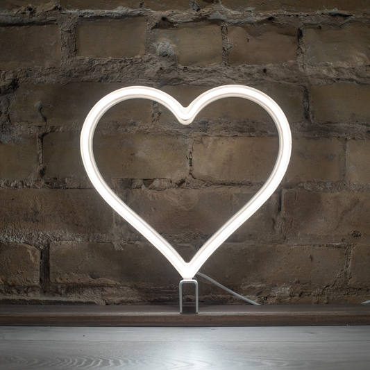 Cool white neon heart art glowing against a brick wall - 12 inch LED neon heart light by Our Glowing Hearts, handmade in Canada