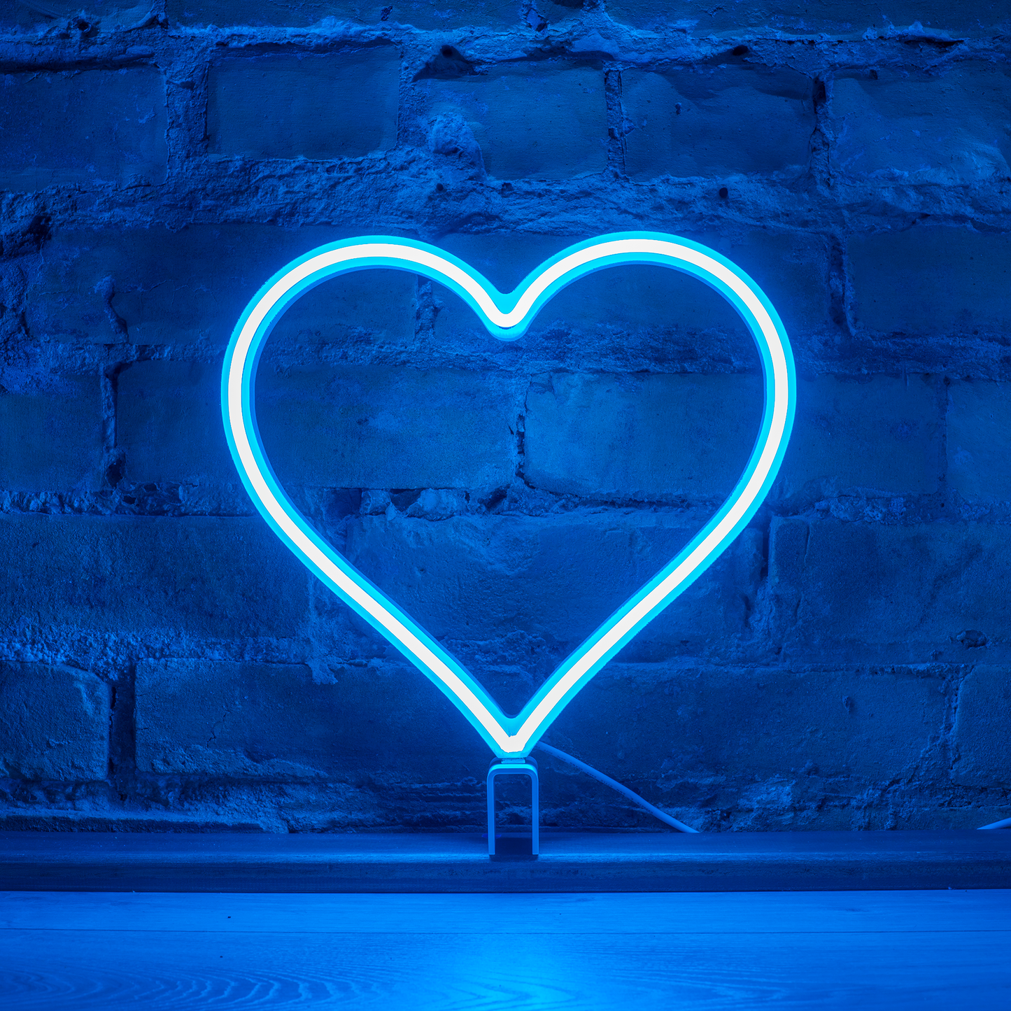 Cyan neon heart art glowing against a brick wall - 12 inch LED neon heart light by Our Glowing Hearts, handmade in Canada