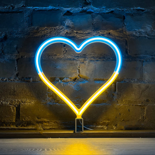 Love Ukraine neon heart art in blue and yellow glowing against a brick wall - 12 inch LED neon heart light in Ukraine flag colors by Our Glowing Hearts, handmade in Canada