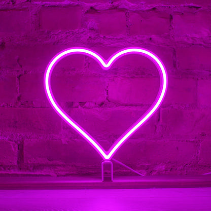 Magenta neon heart art glowing against a brick wall - 12 inch LED neon heart light by Our Glowing Hearts, handmade in Canada