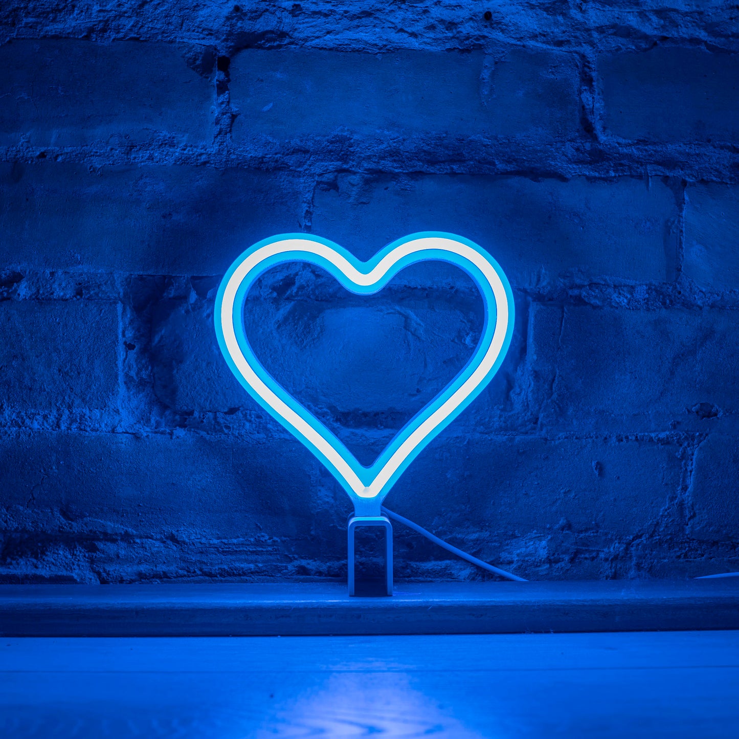 Mini cyan neon heart art glowing against a brick wall - 7 inch LED neon heart light by Our Glowing Hearts handmade in Canada