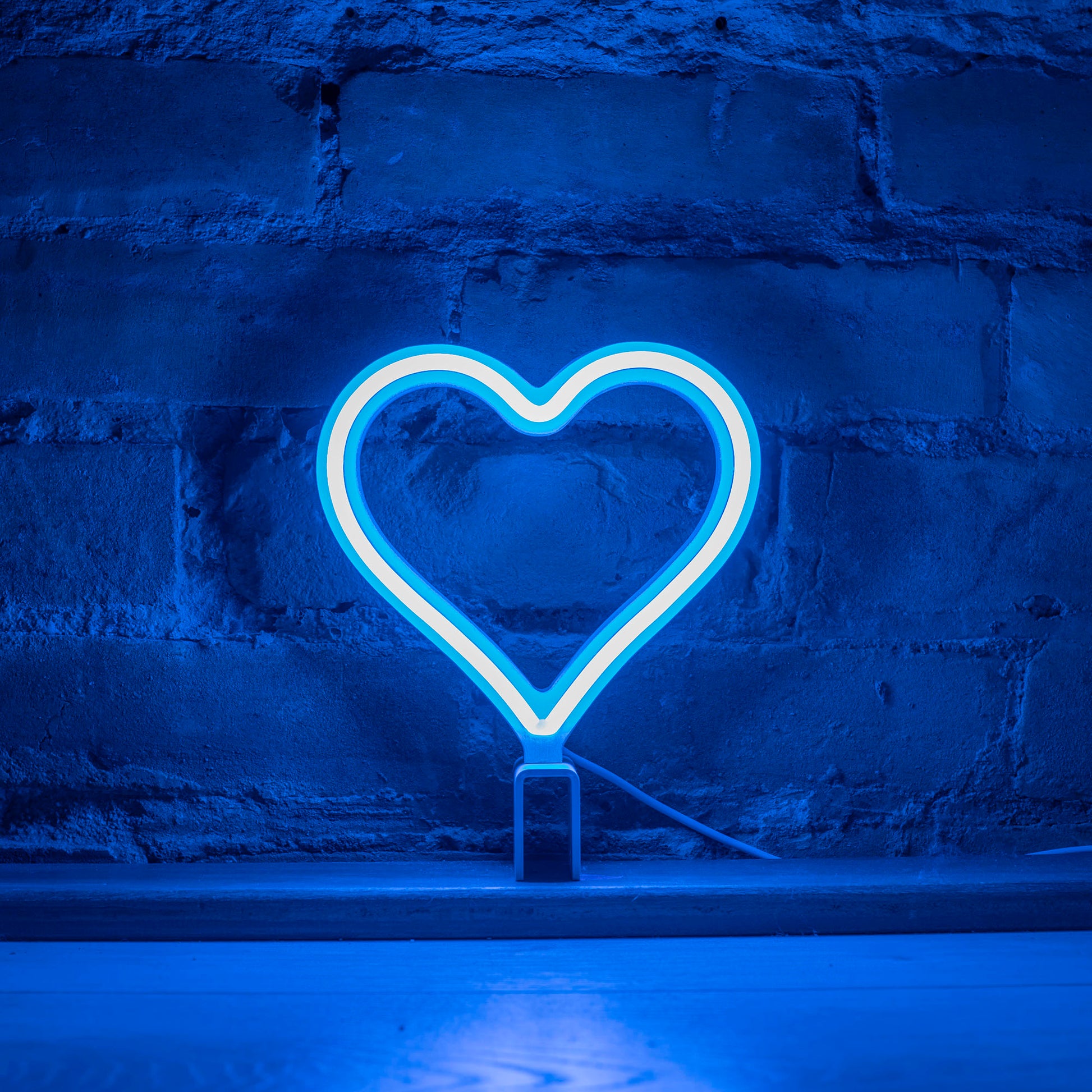 Mini cyan neon heart art glowing against a brick wall - 7 inch LED neon heart light by Our Glowing Hearts handmade in Canada