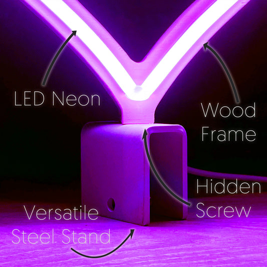 Close-up of mini magenta neon heart art construction showing LED neon tubing wood frame hidden screw mount and versatile steel baseplate stand by Our Glowing Hearts
