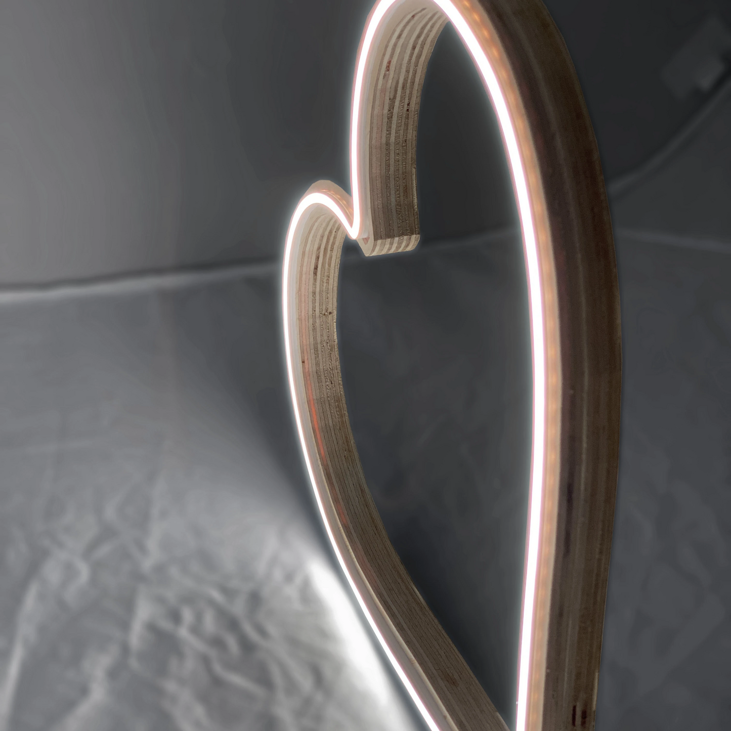 Close-up of neon heart art showing laminated wood frame and LED neon tubing detail - handcrafted heart-shaped wall art by Our Glowing Hearts, handmade in Canada