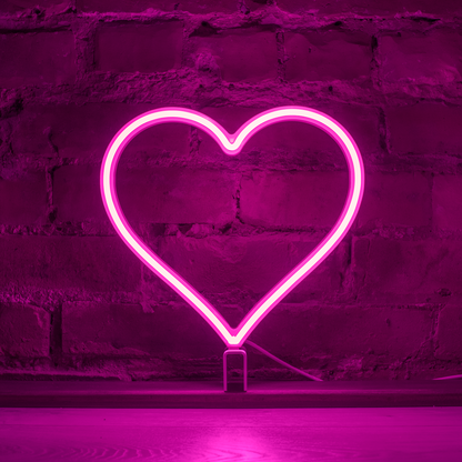 Pink neon heart art glowing against a brick wall - 12 inch LED neon heart light by Our Glowing Hearts, handmade in Canada