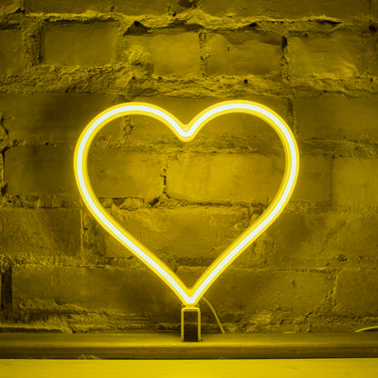 Yellow neon heart art glowing against a brick wall - 12 inch LED neon heart light by Our Glowing Hearts, handmade in Canada